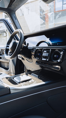 Interior view of a modern car dashboard with controls and steering wheel shown in detail