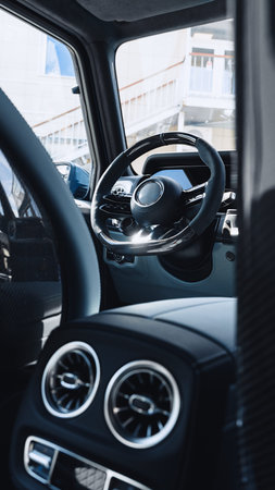 Steering wheel and dashboard view from inside a modern car with stylish design