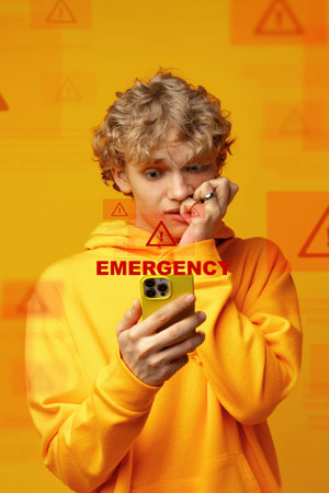 Young person checks phone during emergency event at home in the daytime while looking worried and concerned