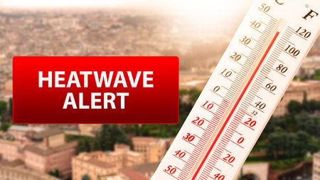 Heatwave alert shows high temperature on thermometer over city background during summer season