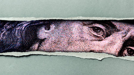 Details of a dollar bill showing a close-up of a prominent figure with parts of the bill visible through torn paper
