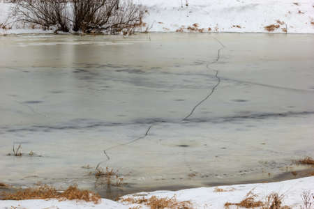 A dangerous crack in the ice, the entire width of the river.の写真素材