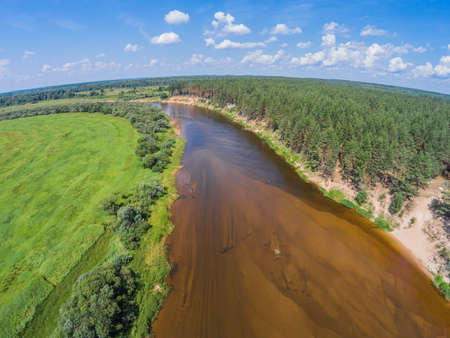 The view from the height of the river Mologa and forest along the sandy shoreの写真素材