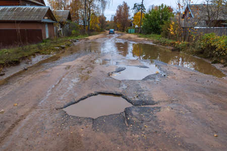 Bad road in the village, holes, hollows.の写真素材