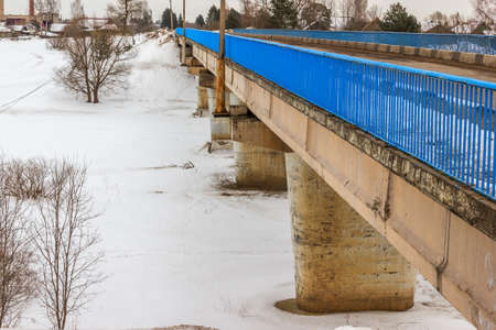 Bridge over the river Mologa. At the bridge, the river under the ice.の写真素材