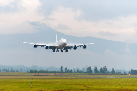 A majestic all-white Boeing 747 wide-body aircraft, unmarked and without airline markings, approaches the runway with its landing gear extended.の写真素材