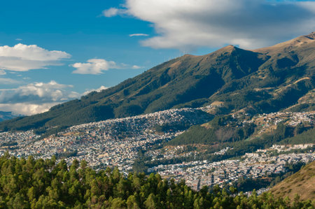 Urban growth in the city of Quito, Ecuador, on the slopes of the Pichincha Mountains, contrasting the density of the metropolis with the natural mountainous environment.の写真素材