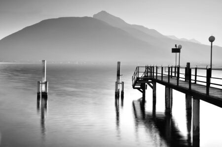 Pacific lake on winter afteroon with pier and a mountain in backgroundの写真素材