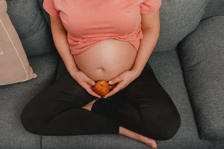 pregnant woman stretching on top of a sofa. Concept of good health during pregnancy. copy spaceの写真素材