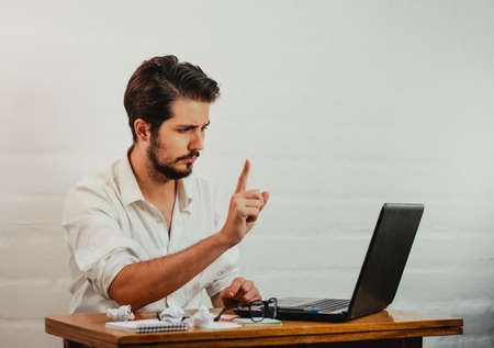 Latin man in glasses working. Using laptop and cell phone. Work at home concept. Copy space.