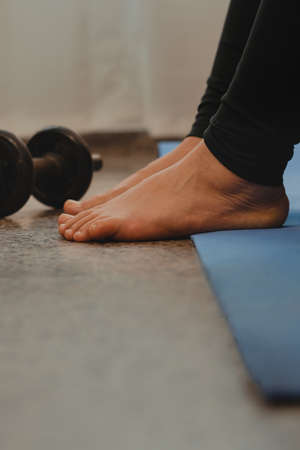 Vertical shot of a pregnant Latina woman stretching after yoga and exercise. Concept of healthy life during pregnancy and exercise at home.の写真素材