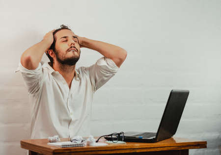 Young man standing pointing a pen at the notebook screen. Close up action. Home Office.の写真素材