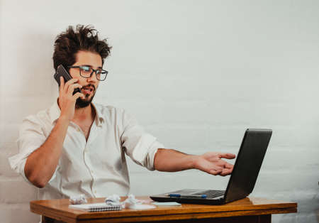 Young man standing pointing a pen at the notebook screen. Close up action. Home Office.の写真素材