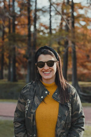 Horizontal shot of a Latina woman in a mask standing alone outside, looking into the distance. Outdoors concept in times . Copy spaceの写真素材