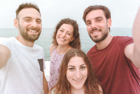 Friends group on vacation take a selife - happy people enjoy their weekend off taking a photograph