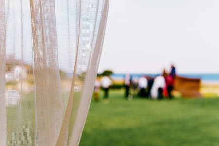 Blurred people having fun at a party in the background with curtain on the left - copyspace on the rightの写真素材