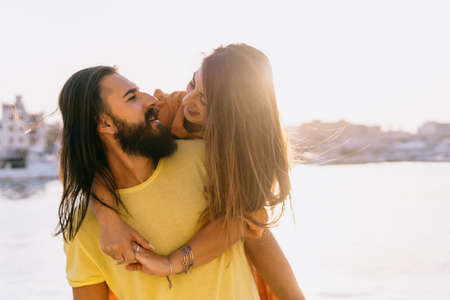 Happy couple on summer vacation hugging each other - love, people and lifestyle concept - copy space on the rightの写真素材