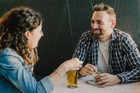 ngaged couple laughs and jokes in a bar - Friends have fun while having a drink in a coffee barの写真素材