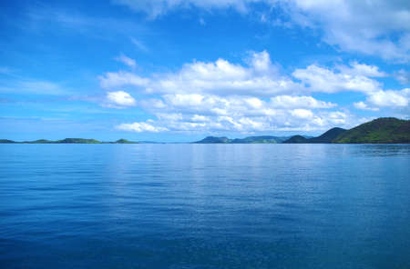 Forested islands in the Philippines archipelago. Isles are surrounded by the blue, calm waters of the ocean and azure, clear sky. There are few clouds, day is very bright and sunny.の写真素材
