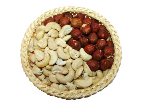 assortment of two types of peanuts in a wooden bowl on whiteの写真素材