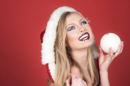 Winter, holiday, party, Christmas, New Year and celebration concept - smiling woman in Santa helper hat holds New Year's toy in hand. Positive emotion.の写真素材