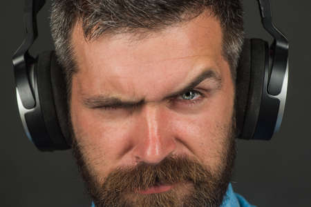 Closeup portrait stylish bearded man with headphones. Modern guy listening to music on headphones. Listening music concept.の写真素材