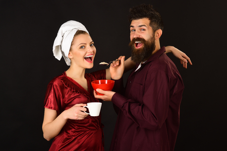 Couple. Loving couple having breakfast smiling at each other. Concept of love, home, food, lifestyle. Happy loving couple enjoying breakfast isolated. Romantic couple eating cereals, drinks coffee.の写真素材