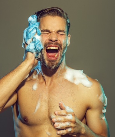 Muscular attractive bearded man taking shower. Portrait of handsome sexy man with naked upper body...
