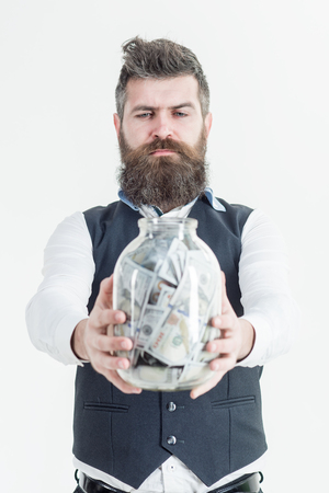 Business man, millionaire, billionaire. Finance. Bearded man holds jar with banknote. Business concept. Banknotes. Saving money concept. Bank advertising. Piggybank. Bearded man holds piggy-bank.の写真素材