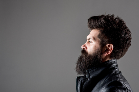 Profile portrait of bearded man. Barber Shop concept. Fashion. Trendy clothes. Bearded man in black jacket. Biker. Leather jacket. Copy space. Advertising concept.の写真素材