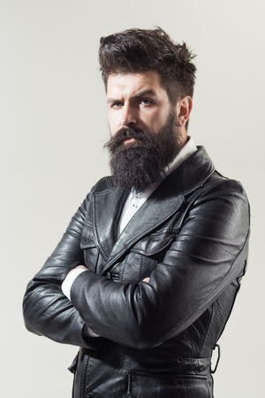 Barber Shop concept. Fashion. Trendy clothes. Bearded man in black jacket. Leather jacket. Advertising concept. Pensive man in leather jacket. Fashion. Trendy clothes.の写真素材