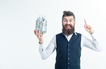 Businessman holds jar full of money banknotes. Business man raised finger up holds jar with dollars....