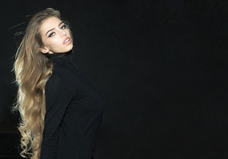 Beautiful fashion female model with long wavy hair. Sensual woman with healthy long hair. Beautiful sensual girl with long curly hair. Girl with elegant hairstyle. Copy space for advertise barbershop.の写真素材