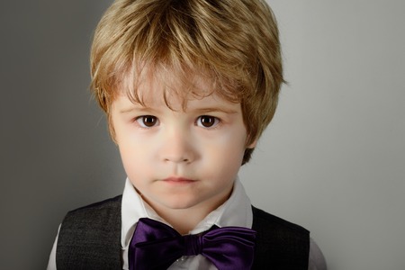 Fashionable little boy in bow tie. Stylish kid. Cute solemn little boy wearing bow tie. Small stylish toddler in bowtie. Bow-tie. Cute blonde boy dressed like professor. Kid fashion, beauty, style.の写真素材