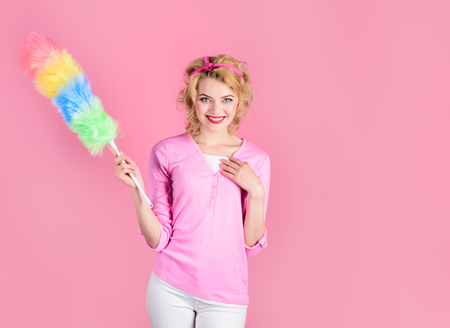 Cleaning woman. Happy girl hold colorful duster brush. Cleaning service. Girl cleaner with feather...