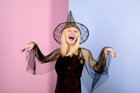 Carnival costume. Halloween dresses on witch. Sexy woman in black witch halloween costumes on party. Happy girl dressed up in halloween costume of witch. Halloween art. Magical witch girl in hat.の写真素材