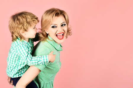 Happy family. Mother and son smiling. Blond mother holding boy on piggyback. Family time together. Motherhood concept. Mom and toddler having fun together. Little kid express love to mommy. Copy spaceの写真素材