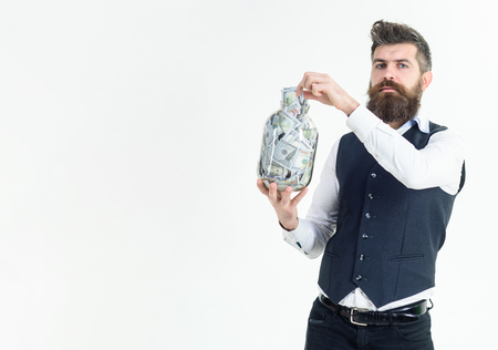 Glass jar that is used by business man as piggy bank. Man put dollars in jar. Business, finance&investment. Saving money by put in jar. Saving money accounting concept. Banknotes. Dollars in glass jarの写真素材