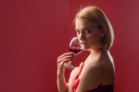 Attractive woman drinking red wine. Stylish woman in restaurant celebrate new year or Christmas. Holidays celebration concept. Copy space for advertise.の写真素材