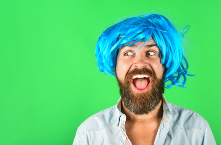 Funny bearded man wearing blue wig. Handsome bearded man with stylish mustache in wig. Fashion, art and creativity concept. Barbershop. Hipster in periwig. Happy stylish man in blue hair. Copy space.の写真素材