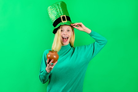 Saint Patrick's Day. Green top hat. Girl in green top hat holds pot with gold. Leprechaun. Green leprechaun. Green hat with clover. Irish Traditions. Leprechaun costume. Pot with gold.の写真素材