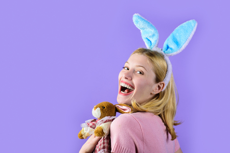 Happy easter! Girl with plush bunny toy. Easter. Spring holidays. Easter Day. Happy girl with bunny ears. Pretty girl holds plush bunny. Easter hunt. Bunny ears. Sale. Discount. Plush rabbit.の写真素材
