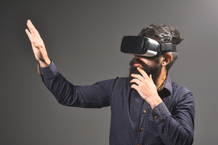 Best virtual reality headset. Virtual reality glasses for smartphone. Virtual reality&future of presentations. Bearded man in VR device.Connection technology with science, augmented future, global webの写真素材