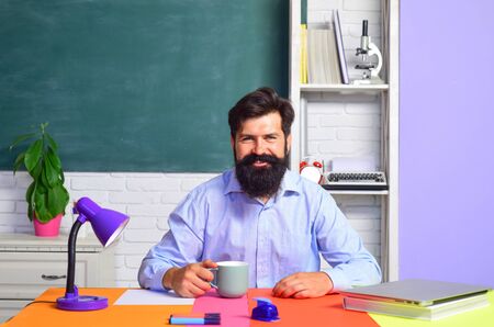 Back to school. Portrait of smiling male teacher in class. Learning and education concept. Bearded...