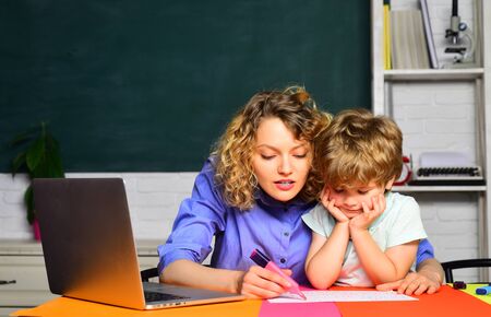Elementary school. First day at school. Little kid learning with mother. Education. Homework. Teachers day. School kid. Homework. Lessons. School subjects.の写真素材