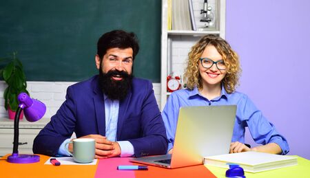 Couple of teachers in classroom. World teachers day. Homework. School job. High school concept. Student in college. Bearded professor. Smiling teachers at work.の写真素材