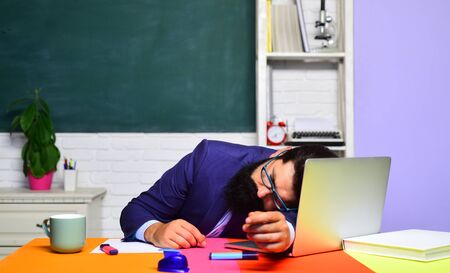 School job. Teacher preparing for university exams. Education concept. World teachers day. Back to school. Knowledge and educational school concept. Tired teacher sleeping in classroom. Hard work.の写真素材