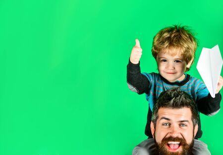 Travel agency. Smiling father&happy son with paper aeroplane in hands showing thumb up. Travel,...