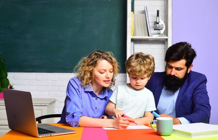 Kids gets ready for school. Learning and education concept. Teachers day. Education for children out of school. Couple helping his son to make homework. September 1. Family school. Elementary student.の写真素材