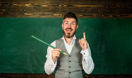 University student writing with big pencil. Happy educator, teacher with pencil in hand. Educational or academic concept. Teacher in classroom. Back to school. School equipment. School supplies.の写真素材